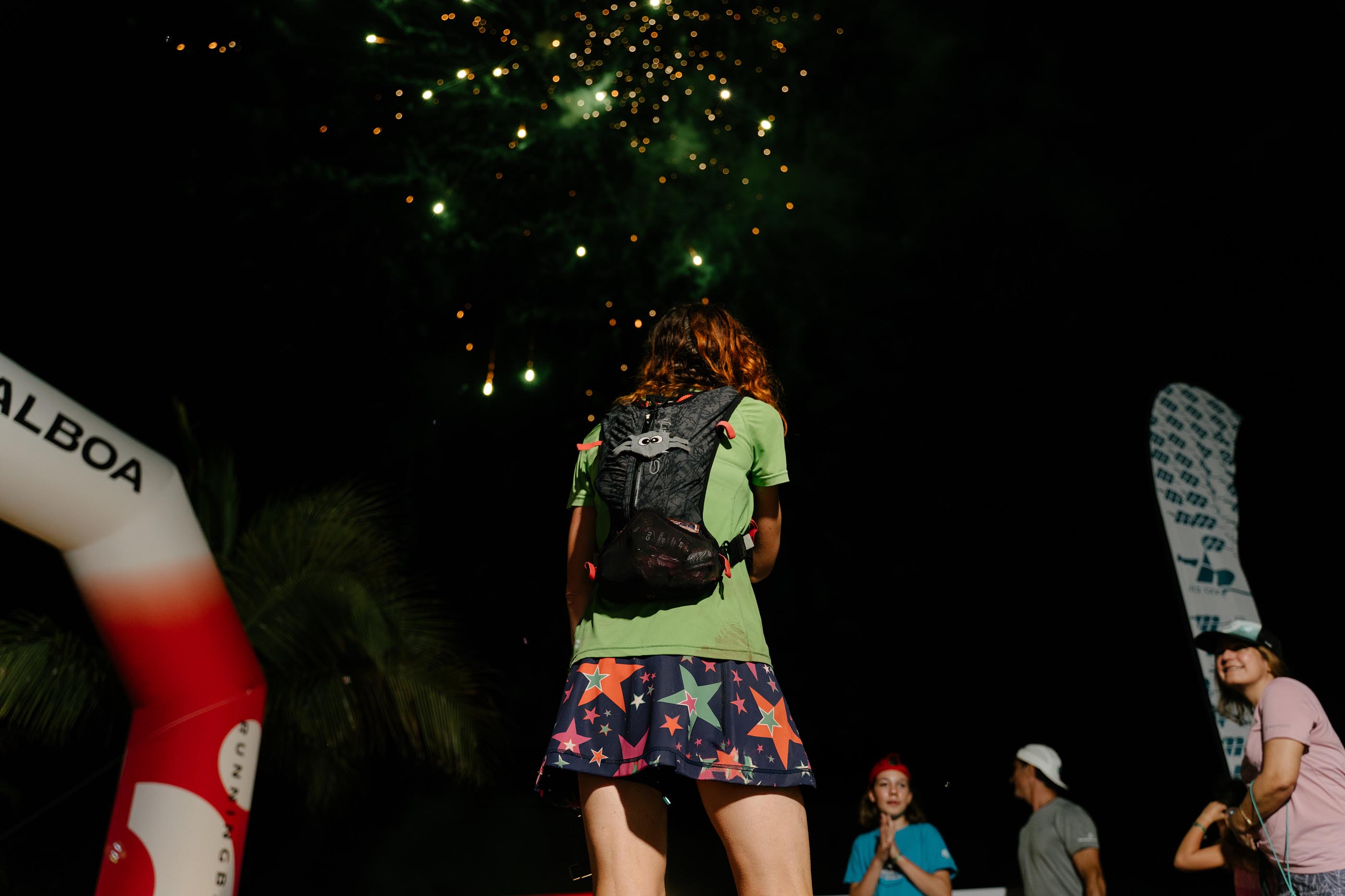 Corredora en la meta nocturna bajo los fuegos artificiales de El Reto del Indio